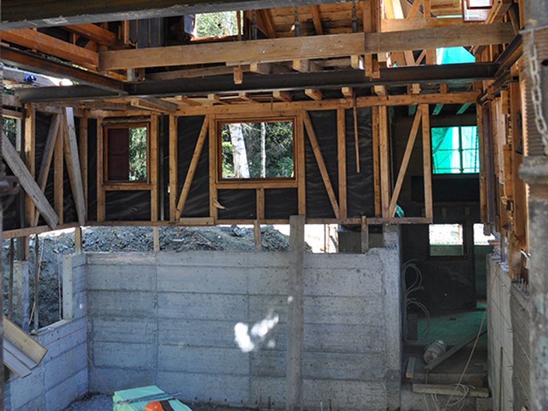 Chantier de Chermignon : ossature du chalet étayée sur poutres métalliques au-dessus du sous-sol excavé